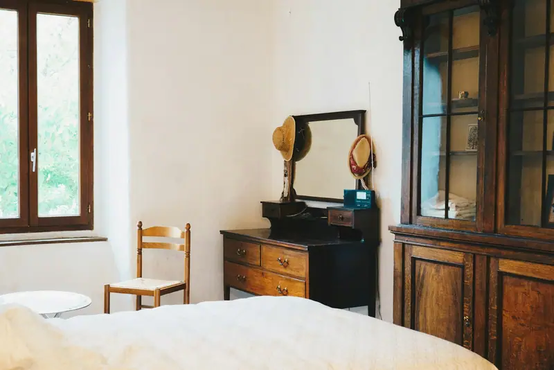 Chambre claire aux murs chaulés, commode et armoire anciennes en bois